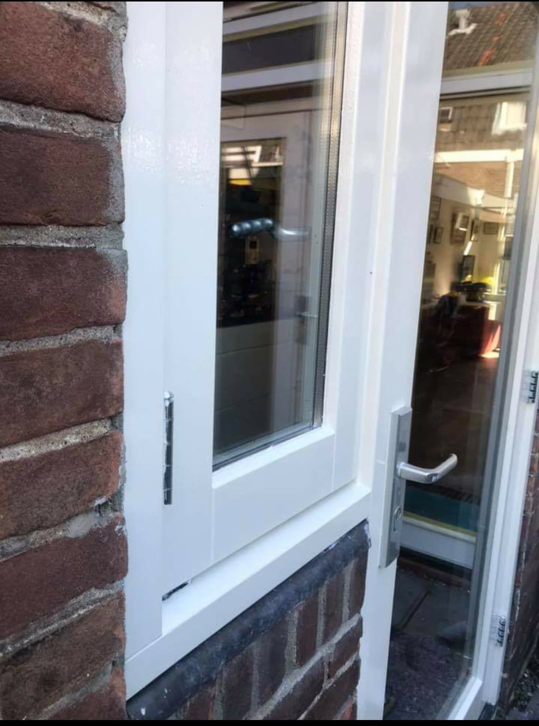 Buitenschilderwerk met witte deur en bakstenen muur